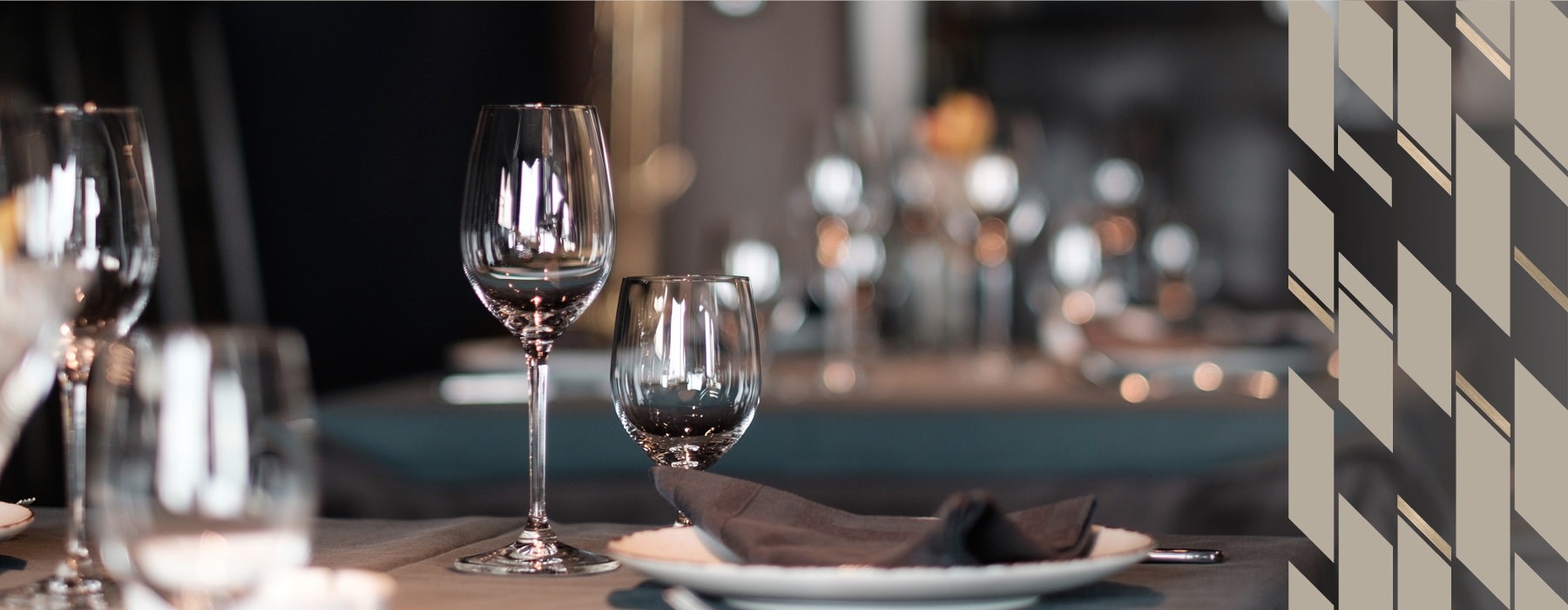 A closeup of plates and wine glasses on a restaurant table